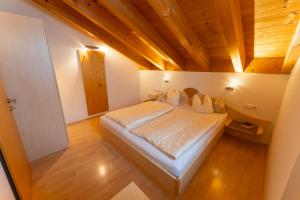 达米尔斯Haus Montana的一间卧室设有一张带木制天花板的大床