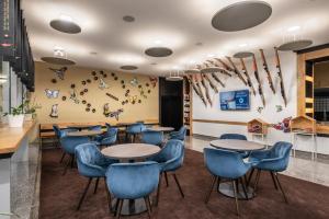 卢布尔雅那Eurostars uHOTEL的一间配备有桌子和蓝色椅子的用餐室