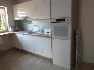 Domek dwupoziomowy的厨房配有白色橱柜和水槽