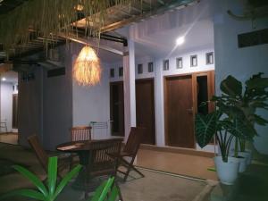 龙目岛库塔Merendeng Hostel Kuta的配有桌椅和吊灯的客房