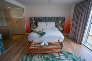 里约热内卢Mercure Rio Boutique Hotel Copacabana的一间卧室配有一张大床,旁边设有长凳