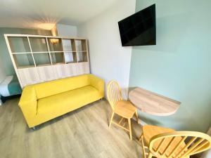 勒阿弗尔L'Escale Appartements et Suites en bord de Mer的客厅配有黄色的沙发和桌子
