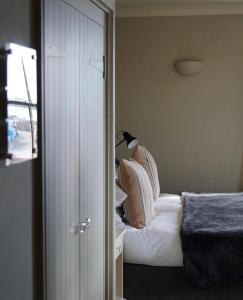 哈里奇码头酒店的一间卧室配有带白色床单和枕头的床。