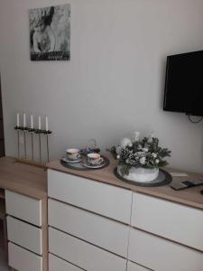 比尔扎伊Upės apartamentai的梳妆台,带桌子,带两个盘子和蜡烛