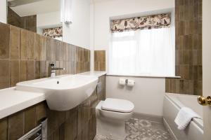 安布尔塞德Wateredge Inn- The Inn Collection Group的浴室配有盥洗盆、卫生间和浴缸。