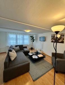罗曼斯霍恩Apartment Romanshorn von Swisspartments的客厅配有沙发和桌子