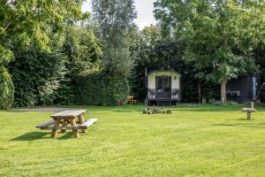邦尼克Camping de Vliert的草原上带野餐桌和拖车的公园