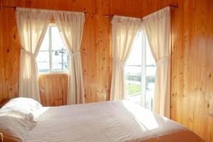 安库德CABAÑAS LAS DALIAS ANCUD的一间卧室设有一张床和一个大窗户