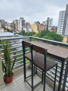 圣米格尔·德·图库玛Monoambiente Confortable Tucuman的阳台配有一张木桌和一把椅子