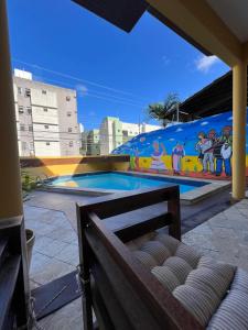 若昂佩索阿Pousada Mangai的一座建筑的一侧,设有一座带壁画的游泳池