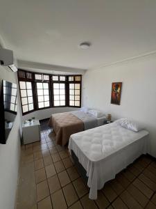 若昂佩索阿Pousada Mangai的一间卧室设有两张床和两个窗户。