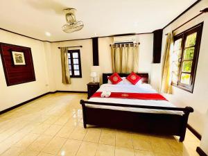 琅勃拉邦Vieng Savanh II Hotel的一间卧室配有一张带红色枕头的床