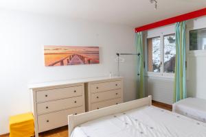 莱森Residence Clos Soleil 22a的一间卧室配有一张床、一个梳妆台和一扇窗户。