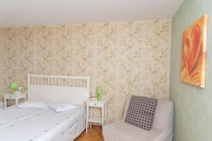 莱森Residence Clos Soleil 22a的卧室配有白色的床和椅子