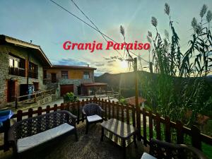 坎加斯-德奥尼斯Hotel Granja Paraíso, Oasis Rural & Bienestar的一座带长椅和围栏的房屋,上面有宏伟的全貌