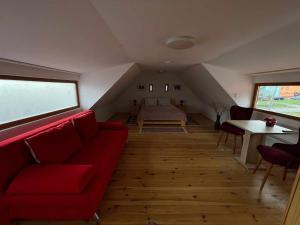 ApoldPensiunea CASA HANN的客厅配有红色的沙发和床。