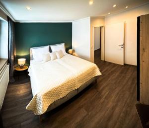 劳里斯Goldberg-Aparts的一间卧室设有一张大床和绿色的墙壁