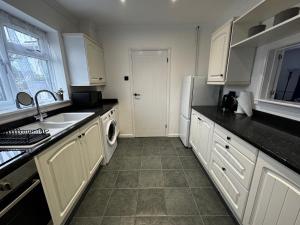 拉姆斯盖特Station house的厨房配有白色橱柜、水槽和洗碗机。