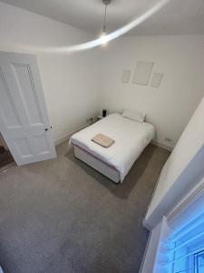 卡莱尔Canvas House的一间白色的卧室,配有床和门