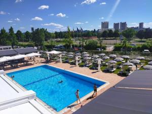 博洛尼亚博洛尼亚米切里诺菲恩拉酒店的享有带遮阳伞的游泳池的顶部景致