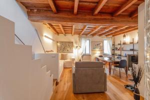 米兰Milan Royal Suites - Castello的一间带木制天花板的客厅和一间餐厅