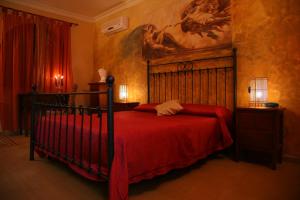 特罗佩阿佩阿特罗历史别墅酒店的一间卧室配有一张红色床罩的床