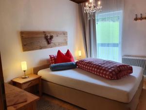 滕嫩山麓圣马丁Boutique Hotel Alpenhof的卧室配有带枕头的床铺和窗户。