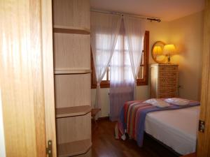 卡尼略Francoli-Vacances Pirinenca的一间卧室配有一张床、一个梳妆台和一扇窗户。