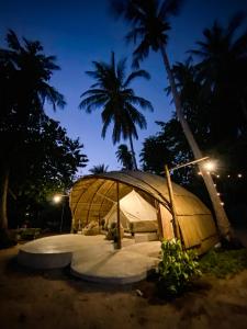 Ko PorThe Por Beach的大型圆顶帐篷,晚上有棕榈树