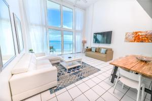 迈阿密海滩SeaStays Apartments的客厅配有白色的沙发和桌子