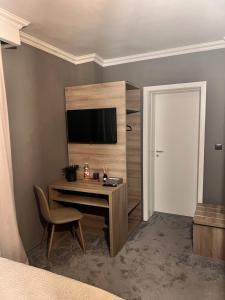 蒂米什瓦拉Hotel Cocó的一间卧室配有一张桌子、一台电视和一扇门