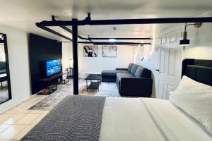 布罗克顿NEW! JXN BnB - Cozy Southshore of Boston的一间卧室配有一张床、一张沙发和一台电视。