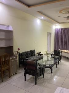 贾姆穆Trikuta Homestay的带沙发和玻璃桌的客厅