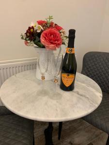 贝尔法斯特Millbrae Lodges的一张桌子,上面放着一瓶香槟和两杯酒杯
