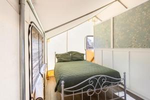 汤姆斯通Silver Spur Homestead Luxury Glamping -The Tombstone的一个小房间的一个床位,设有窗户
