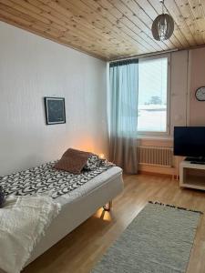 科科拉Apartment Isokatu2的一间卧室设有一张床、一个窗口和一台电视