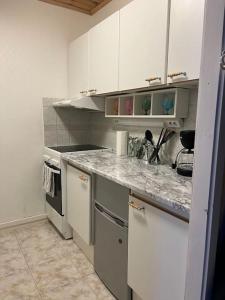 科科拉Apartment Isokatu2的厨房配有白色橱柜和大理石台面