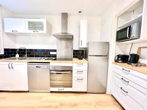 普瓦捷Stay house to Poitiers的厨房配有白色橱柜和不锈钢冰箱
