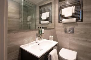 安布尔塞德Windermere Rooms at The Wateredge Inn的一间带水槽、卫生间和镜子的浴室