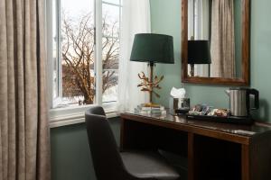 安布尔塞德Windermere Rooms at The Wateredge Inn的一张桌子,旁边是一盏灯和一把椅子