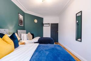 MeanwoodHuge House in Leeds 6BR sleeps13 by PureStay Short Lets的一间卧室设有两张床和蓝色的墙壁