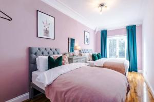 MeanwoodHuge House in Leeds 6BR sleeps13 by PureStay Short Lets的卧室内的两张床,配有粉红色的墙壁和蓝色的窗帘