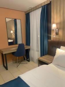 苏黎世Nani City Hotel的酒店客房带一张床、一张书桌和一面镜子