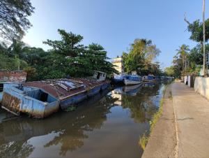 阿勒皮Paddy N Canal Homestay的一群船停在河边,有人行道