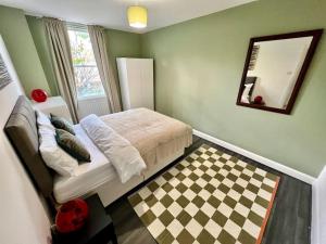伦敦Affordable 2 bedroom flat Tower Bridge/Bermondsey的一间卧室配有一张床和镜子,铺有 ⁇ 形地板