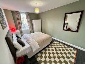 伦敦Affordable 2 bedroom flat Tower Bridge/Bermondsey的一间卧室配有一张床,铺有一个 ⁇ 板地板