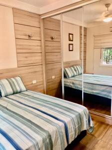 伊瓜苏Casa centro Falls的一间卧室配有两张床和镜子
