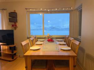 里克斯格伦森Ski in ski out lägenhet med fantastisk utsikt的木制用餐室配有桌椅和大窗户