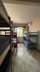 伊达贾伊Fica, Vai ter Bolo Hostel的客房设有三张双层床和一扇窗户。
