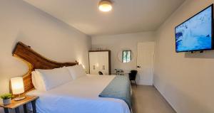科克Anika Boutique Suites的卧室配有白色的床和平面电视。